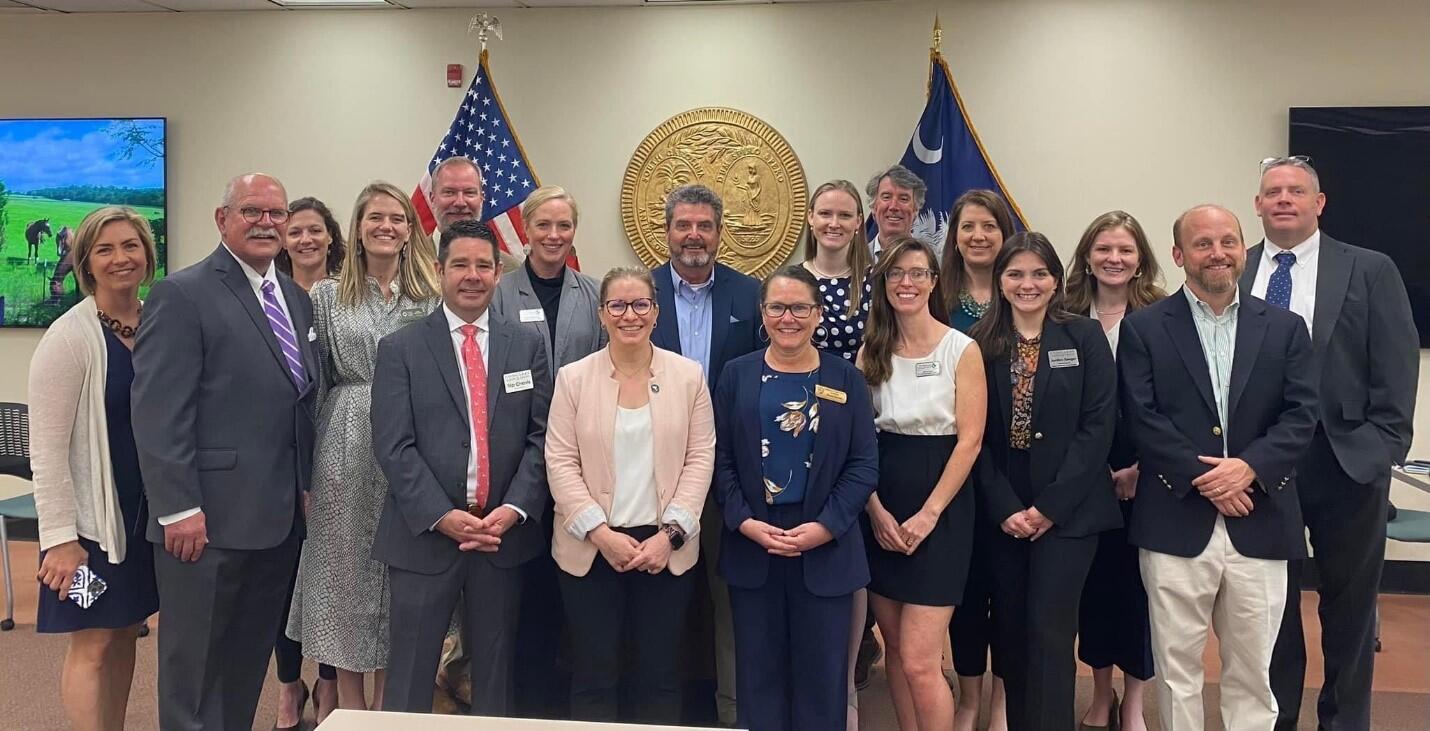 SC Land Trust Network members standing in a legislative room smiling at the camera